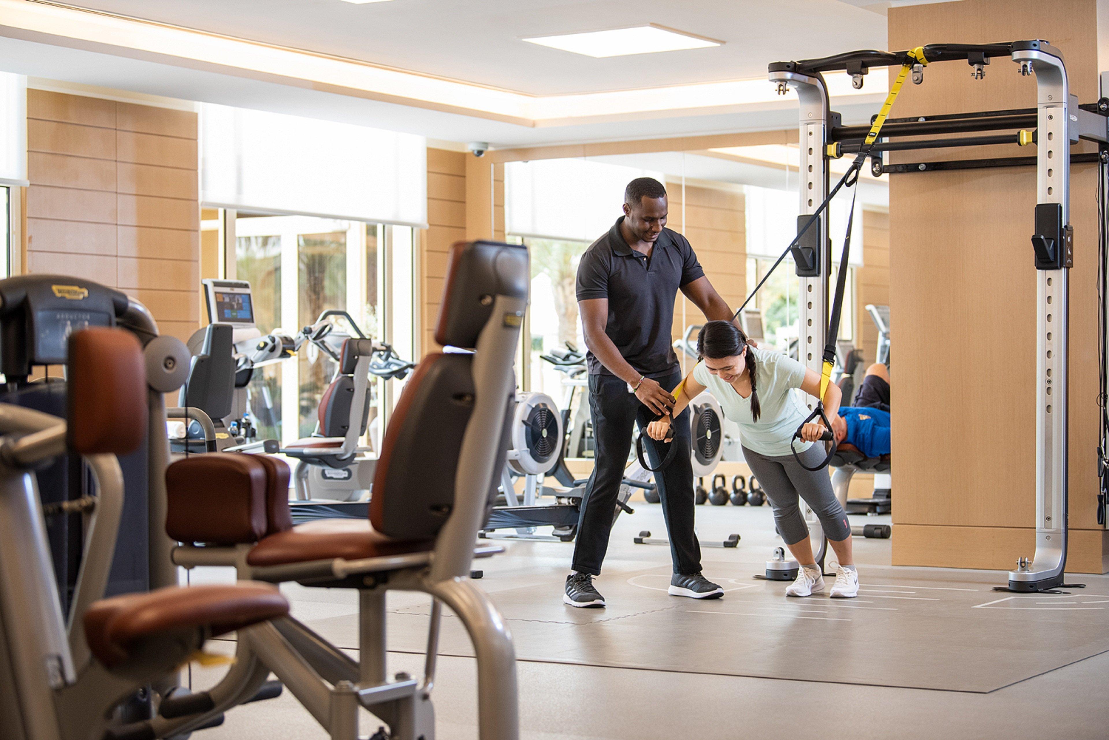 Intercontinental Doha Beach & Spa By Ihg Esterno foto Personal trainer assisting a woman with a workout